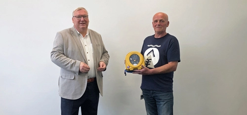 Hans-Peter Marten (l.) überreichte Mieczyslaw Pacanowski (r.), Pförtner bei der MC-Bauchemie, einen Defibrillator. 