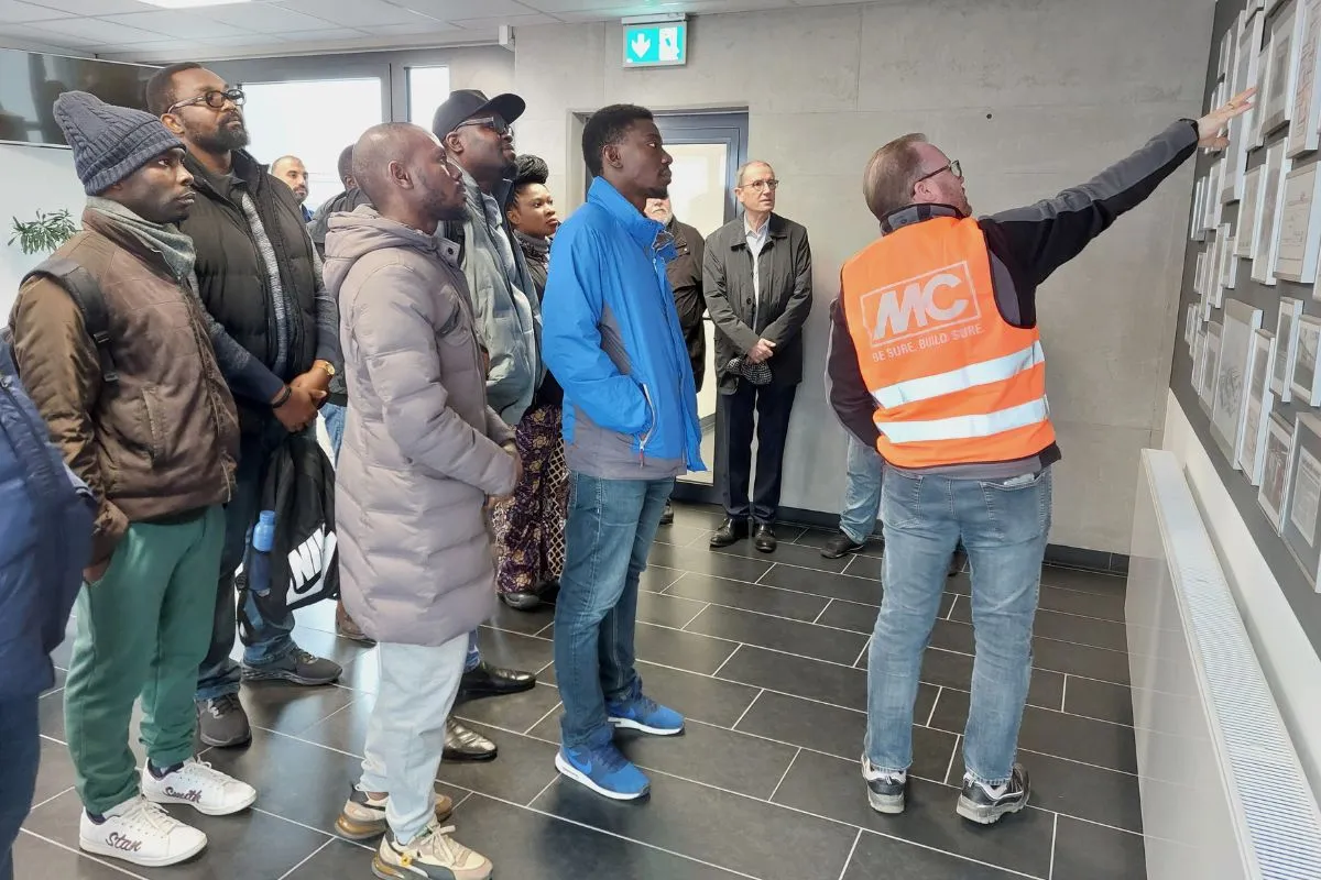 MC-Mitarbeiter Sascha Kaufmann präsentiert den nigerianischen Gästen auch Historisches zum Unternehmen.