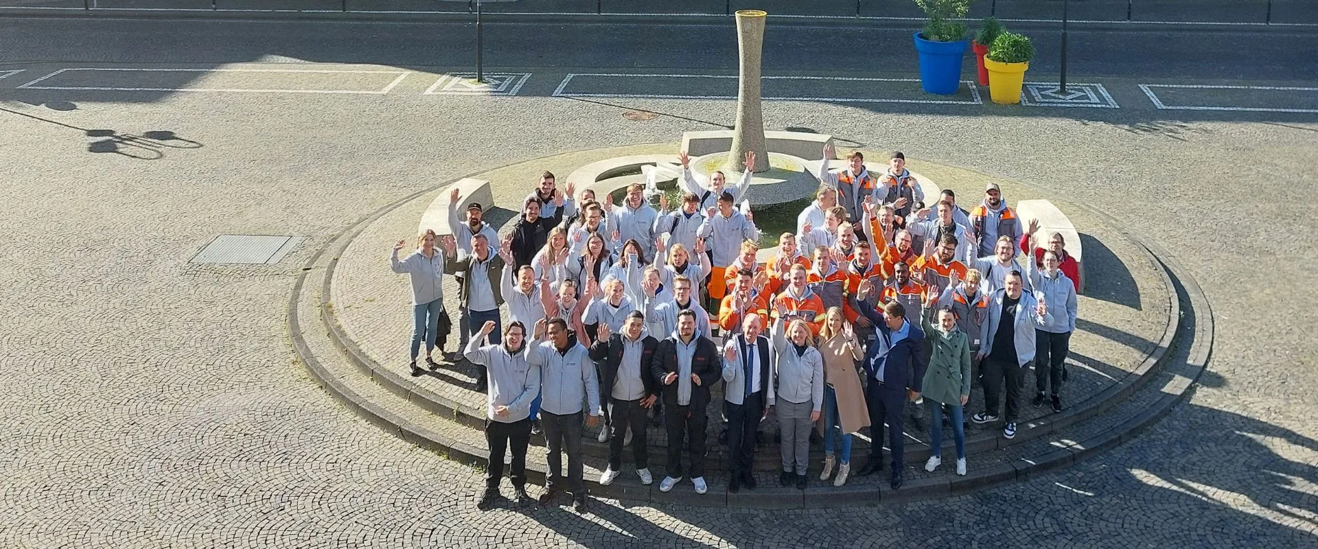 Alle Teilnehmenden stehen gemeinsam mit Oberbürgermeister Bernd Tischler vor dem Brunnen am Bottroper Rathausplatz.
